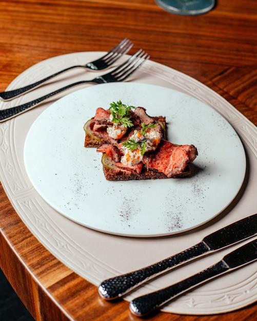 Een bovenaanzicht gebakken vlees lekker en gezouten met bestek op tafel eten vleesmaaltijd restaurant