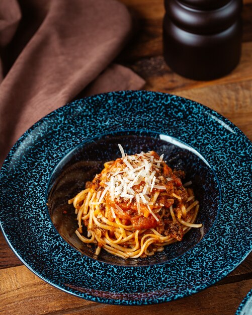 Een bovenaanzicht gekookte pasta binnen plaat op de bruine tafel pasta eten maaltijd diner