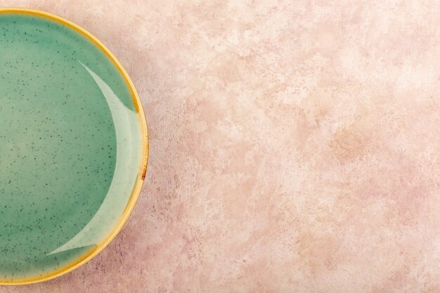 Een bovenaanzicht groene ronde plaat leeg glas gemaakt geïsoleerde maaltijd tafel