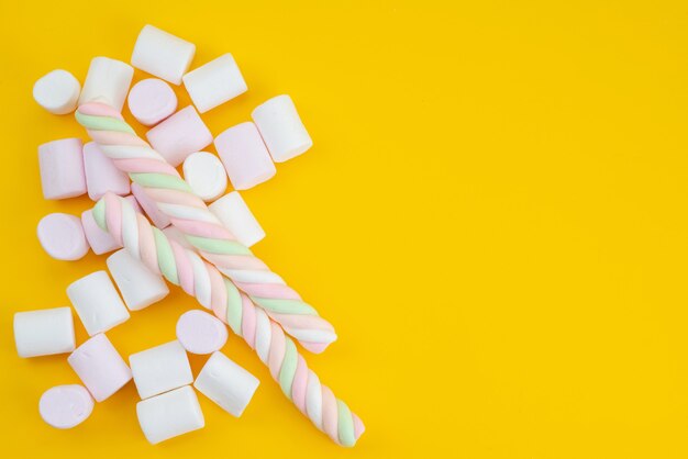 Een bovenaanzicht heerlijke marshmallows op gele, suikerzoete kleurensuikergoed