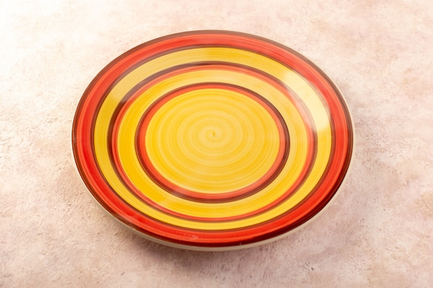 Een bovenaanzicht kleurrijke ronde plaat leeg glas gemaakt geïsoleerde maaltijd tafel kleur