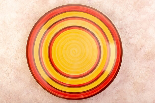 Een bovenaanzicht kleurrijke ronde plaat leeg glas gemaakt geïsoleerde maaltijd tafel kleur