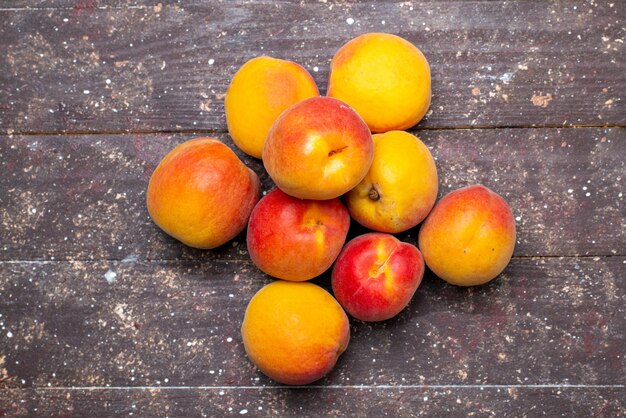 Een bovenaanzicht perziken zacht en sappig op het houten bureau fruit zomerpulp