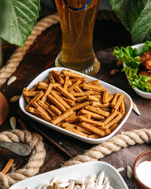 Een bovenaanzicht pittige crackers in witte plaat op de houten bureau snack cracker beschuit