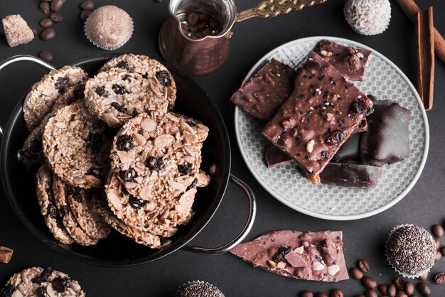 Een bovenaanzicht van chocolade muesli-koekjes en truffels op zwarte drop