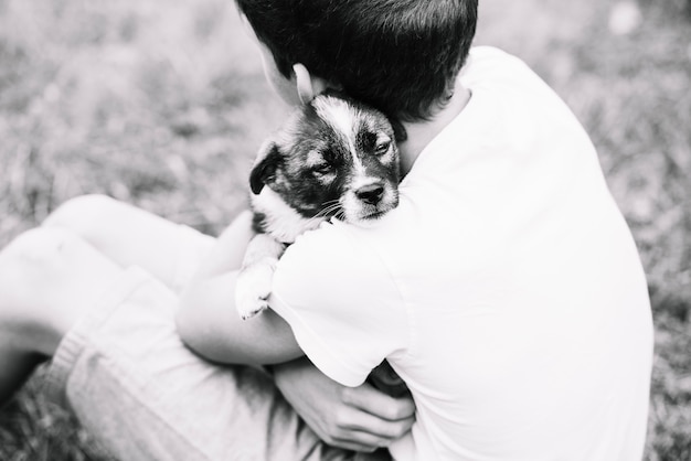 Gratis foto een bovenaanzicht van de jongen omarmen zijn mooie puppy