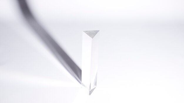 Een bovenaanzicht van driehoekige prisma met donkere schaduw op witte achtergrond
