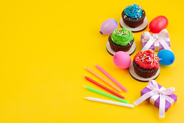 Een bovenaanzicht van heerlijke brownies op basis van chocolade, samen met snoepjes en ballen op gele, snoepcake koekjeskleur