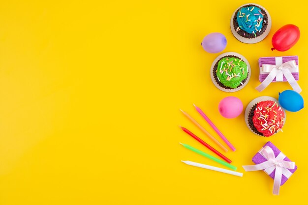 Een bovenaanzicht van heerlijke brownies op basis van chocolade, samen met snoepjes en ballen op gele, snoepcake koekjeskleur