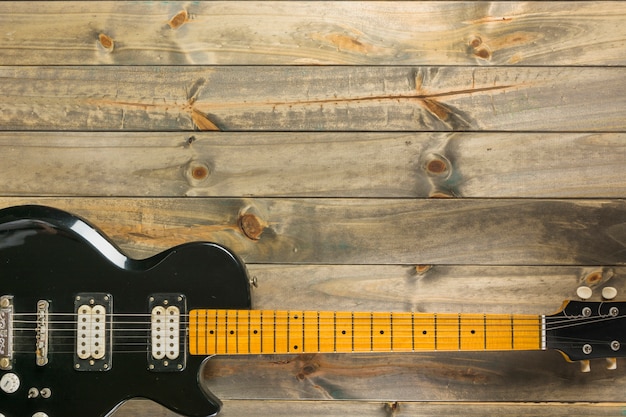 Een bovenaanzicht van klassieke elektrische gitaar op houten tafel