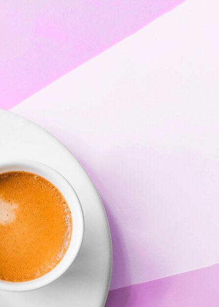 Een bovenaanzicht van koffiekopje op roze achtergrond