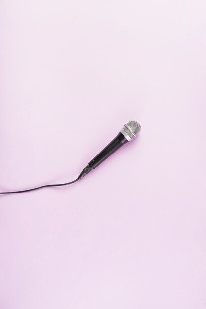 Een bovenaanzicht van microfoon op roze achtergrond