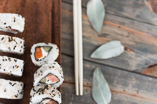 Een bovenaanzicht van sushi met eetstokjes over de tafel