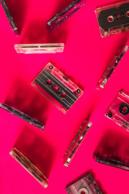 Een bovenaanzicht van transparante cassette tape op roze achtergrond