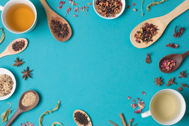 Een bovenaanzicht van verschillende gedroogde kruiden en thee op blauwe achtergrond