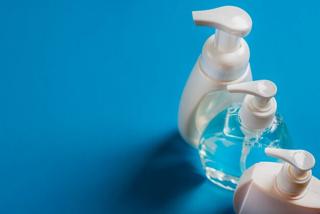 Een bovenaanzicht van zeep dispenser flessen op blauwe achtergrond