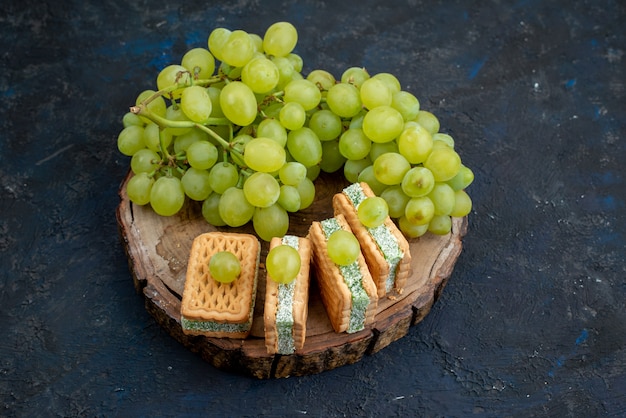 Een bovenaanzicht verse groene druiven zuur sappig en zacht met koekjes op de donkere achtergrond fruit rijp plant groen