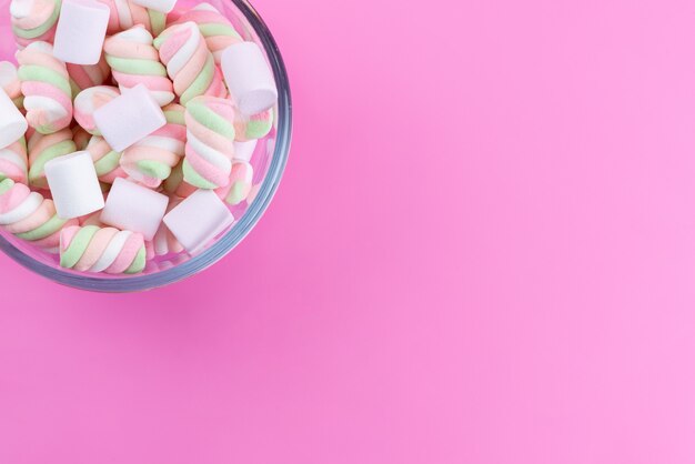 Een bovenaanzicht wit-roze marshmallows zoet en plakkerig op roze