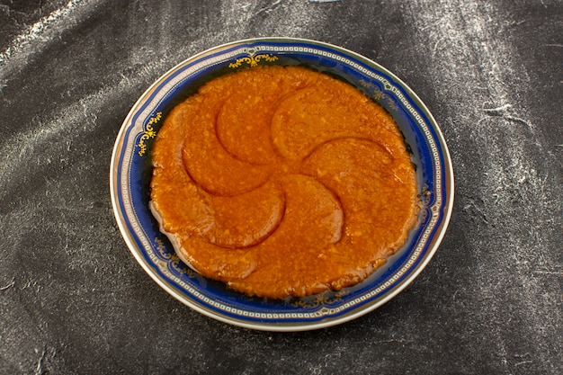 Een bovenaanzicht zoete heerlijke halva lekker Oosters eten binnen plaat op het donkere oppervlak