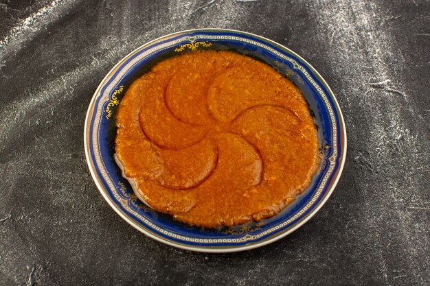 Een bovenaanzicht zoete heerlijke halva lekker Oosters eten binnen plaat op het donkere oppervlak