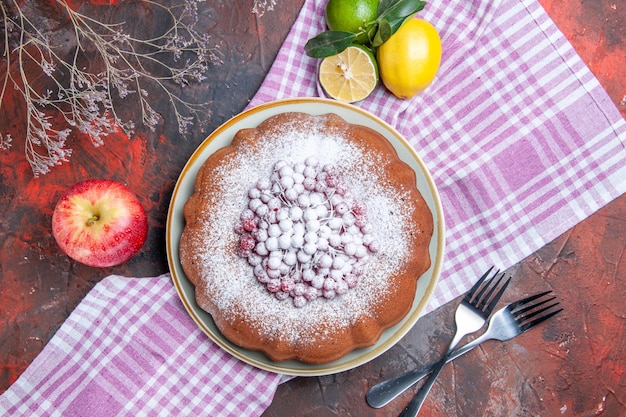 Gratis foto een cake een smakelijke cake met bessen bladeren citrusvruchten op het tafelkleed