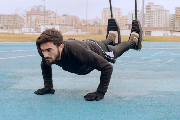 Gratis foto een calisthenics-instructeur traint op de turnringen