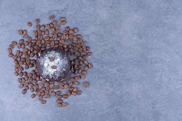 Een chocolademuffin met koffiebonen en suikerpoeder