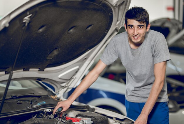 Een collega-benchman die de motor van een auto repareert