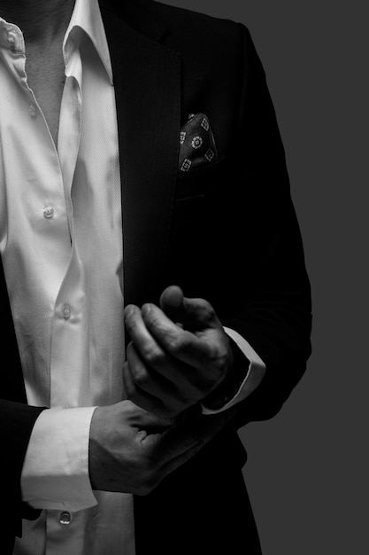 Gratis foto een deel van zwart-wit portret van man in een pak op donkergrijze achtergrond.