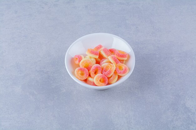 Een diep bord vol kleurrijke, suikerachtige fruitmarmelades