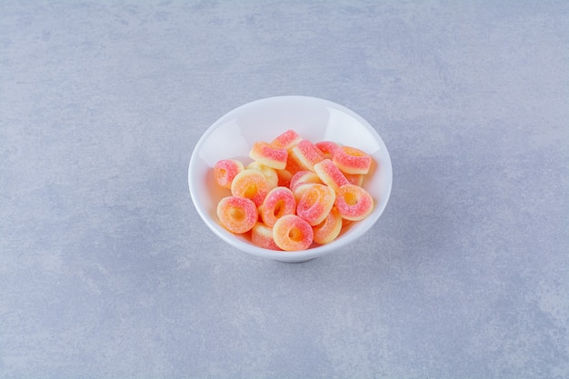 Een diep bord vol kleurrijke, suikerachtige fruitmarmelades