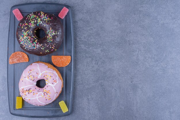 Een donker bord vol donuts en zoete gelei