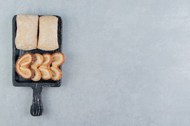 Een donkere houten plank met zoete hartvormige koekjes.