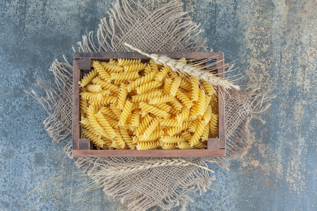 Een doos fusilli pasta, op het marmeren oppervlak.