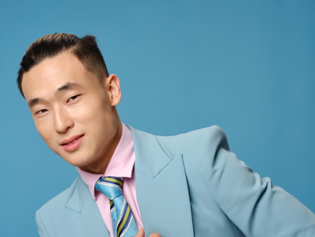 Een elegante man in een klassiek pak op een blauwe achtergrond leunde opzij Premium Foto
