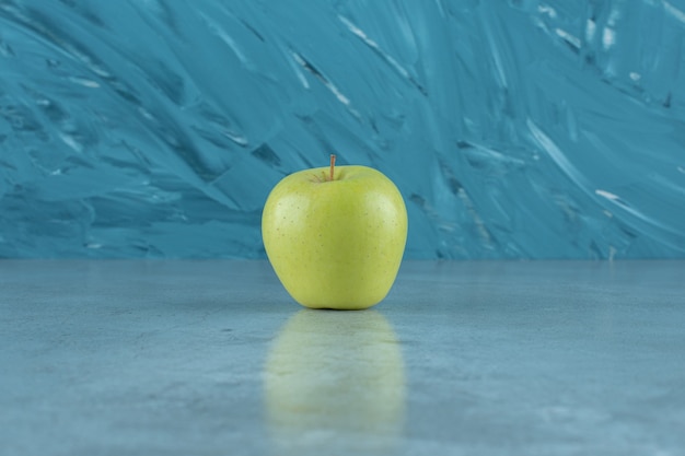 Een enkele rijpe appel, op de marmeren achtergrond.