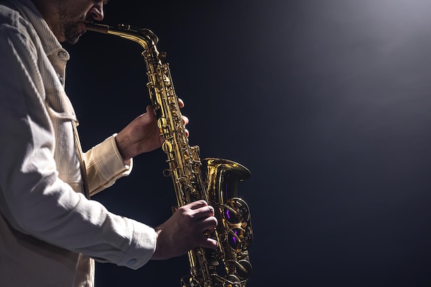 Een europese man speelt saxofoon in het donker