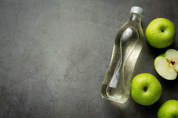 Een fles groene appel gezond sap naast verse groene appels