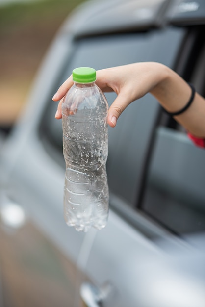 Een fles water vasthouden en de auto uitsteken.