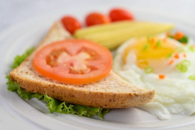 Een gebakken ei tot op een toast, gegarneerd met peper zaden met wortelen, baby maïs en lente-uitjes.