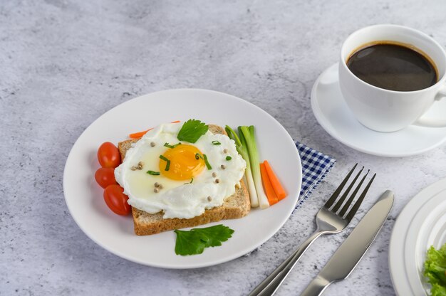 Een gebakken ei tot op een toast, gegarneerd met peper zaden met wortelen en lente-uitjes.