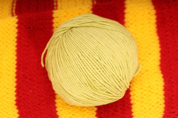 Een gele bol wol ligt op een gebreid servet. hoge kwaliteit foto
