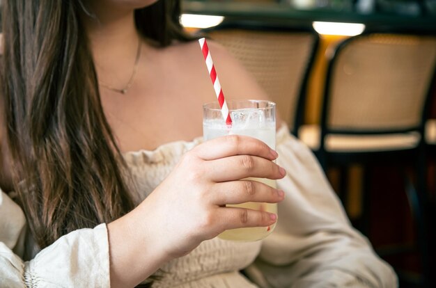 Een glas koude limonade in de hand van een vrouw in een café