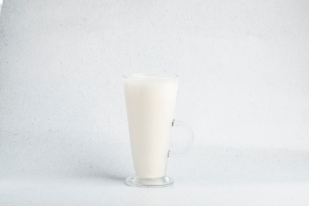 Een glas melk in een witte baclground met kleine schaduw.