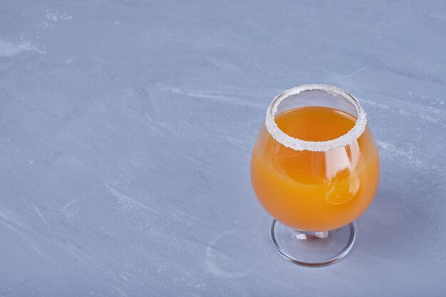 Een glas oranje cocktail.
