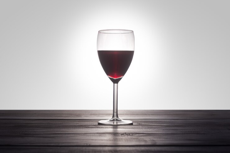 Gratis Foto een glas rode wijn op een houten oppervlak