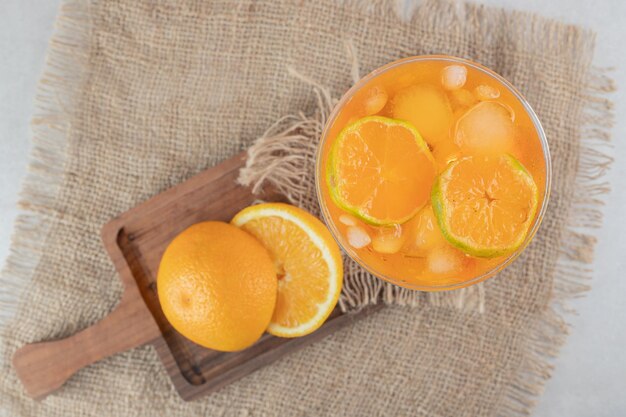 Een glas sap met citrusvruchten op een houten bord
