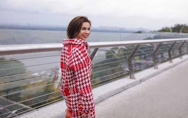 Een glimlachende vrouw van middelbare leeftijd die de herfstkleren draagt.