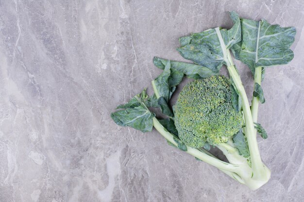 Een groene broccoli geïsoleerd op een marmeren oppervlak