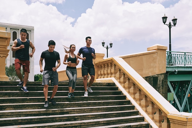 Een groep joggers rennen de trap af op een zonnige zomerdag